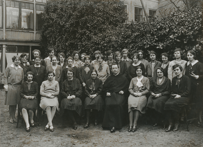 876904 Groepsportret van pater Sebastianus van Nuenen (zittend in het midden) met een groep medewerksters en ...